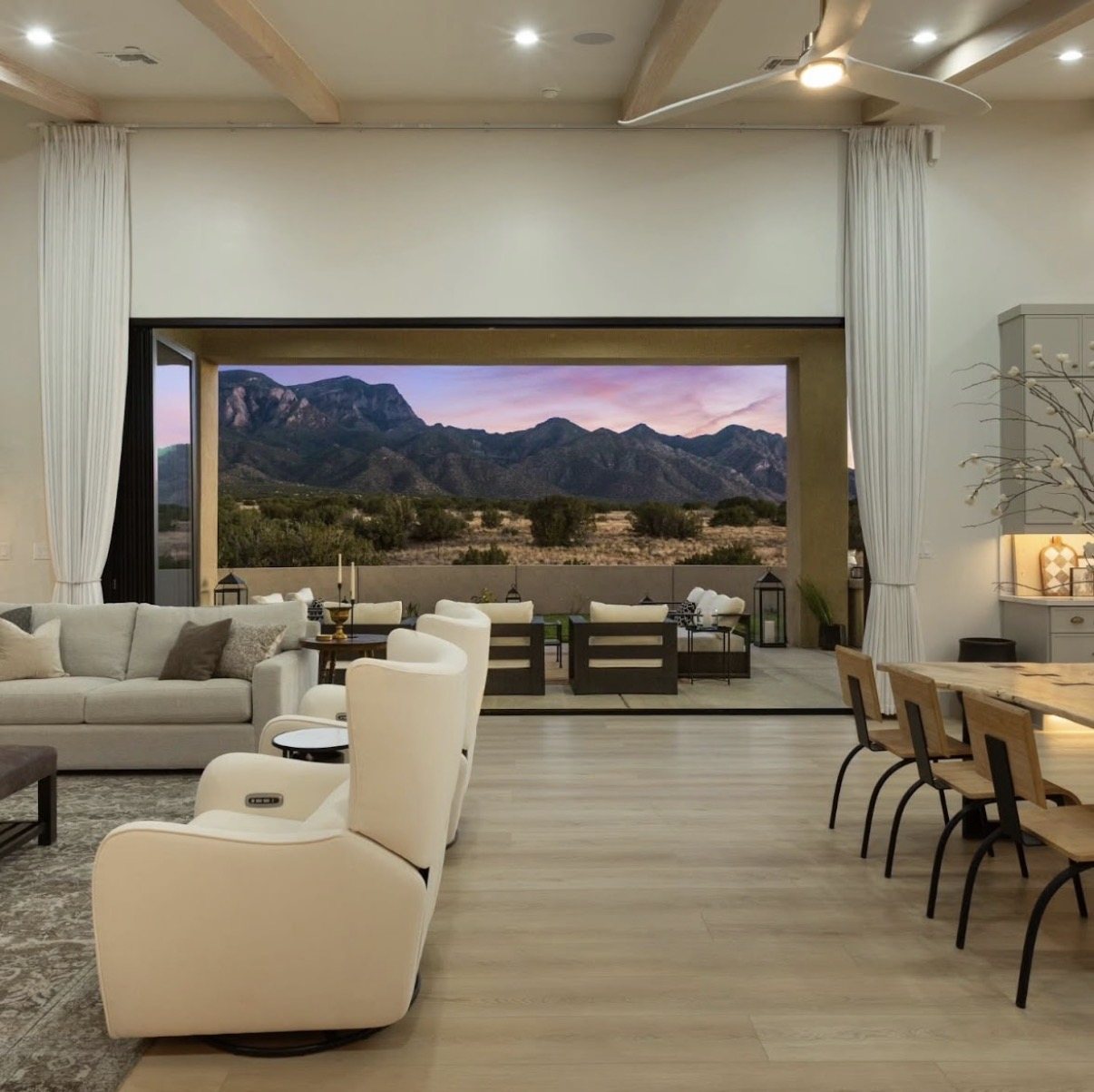 Open-plan living room with a wide opening framing the Sandia Mountains
